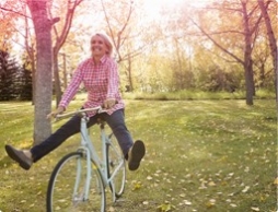 Foto di una donna in bicicletta. L’immagine illustra una donna attiva e in forma, anche durante il ciclo.